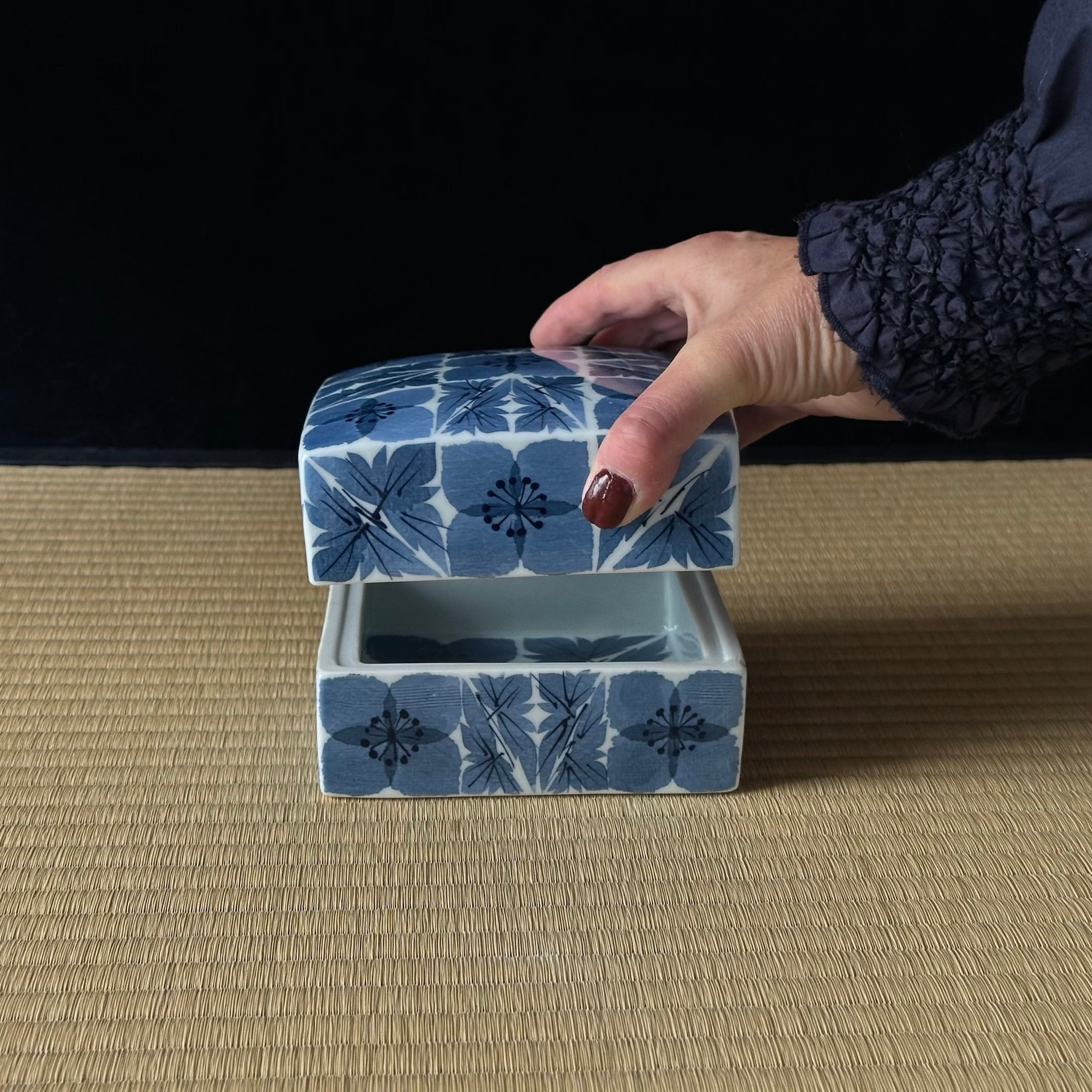 Boîte en porcelaine blanche décorée de fleurs de prunier au washi zome de Katsumi Eguchi, tenue en main pour montrer ses proportions et la finesse de la porcelaine - Atelier Ikiwa