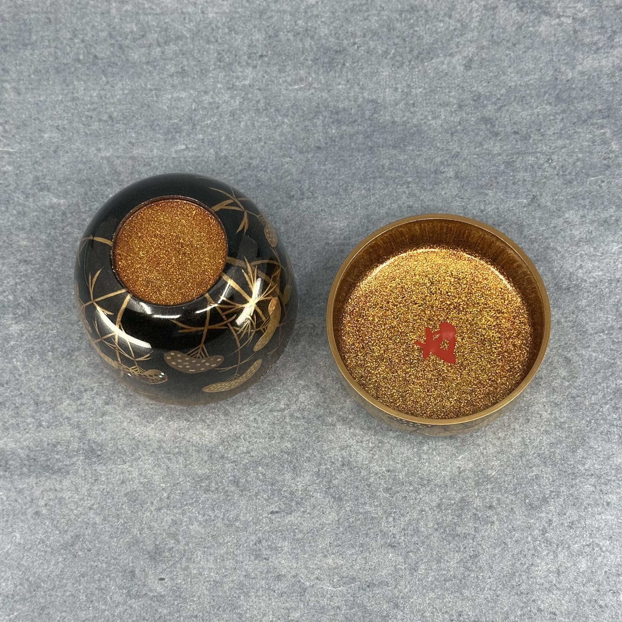 Atelier Ikiwa - gros plan sur le kao rouge du maître de thé Hounsai à l’intérieur du couvercle.