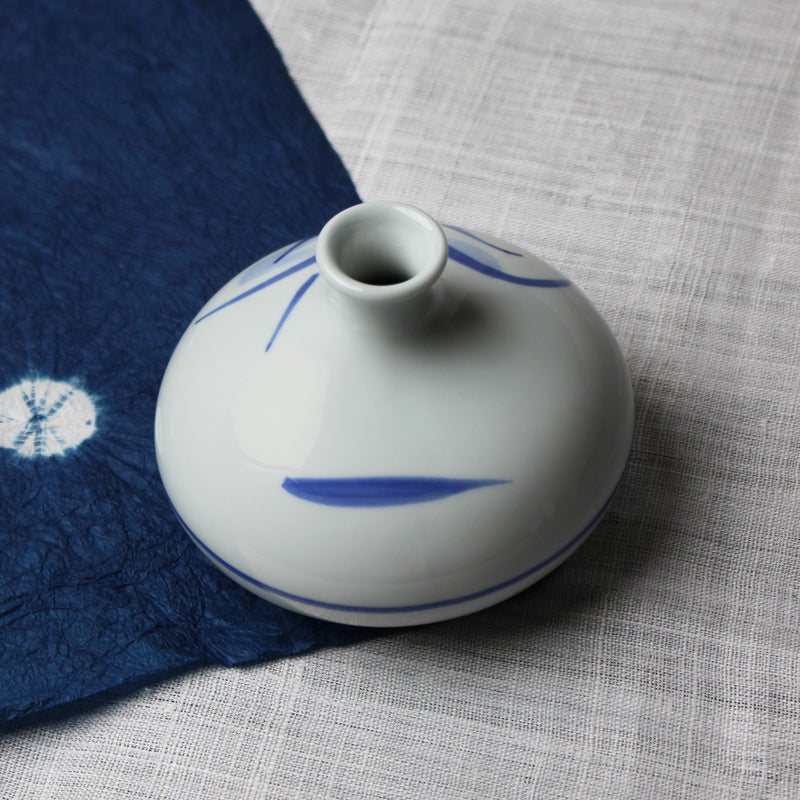Small round white ceramic Japanese vase with blue grass design