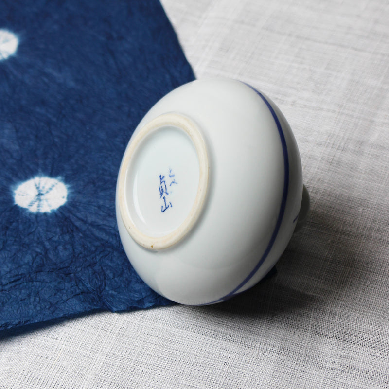Small round white ceramic Japanese vase with blue grass design