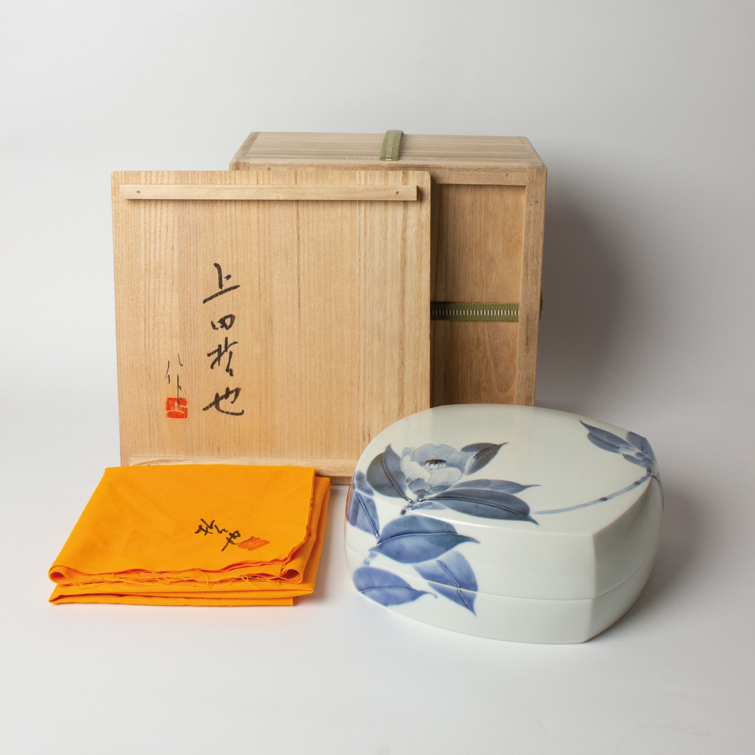 Vue d’ensemble de la boîte en porcelaine japonaise, décor camélia, avec sa boîte en bois gravée. Création artisanale de Tetsuya Ueda pour Atelier Ikiwa.
