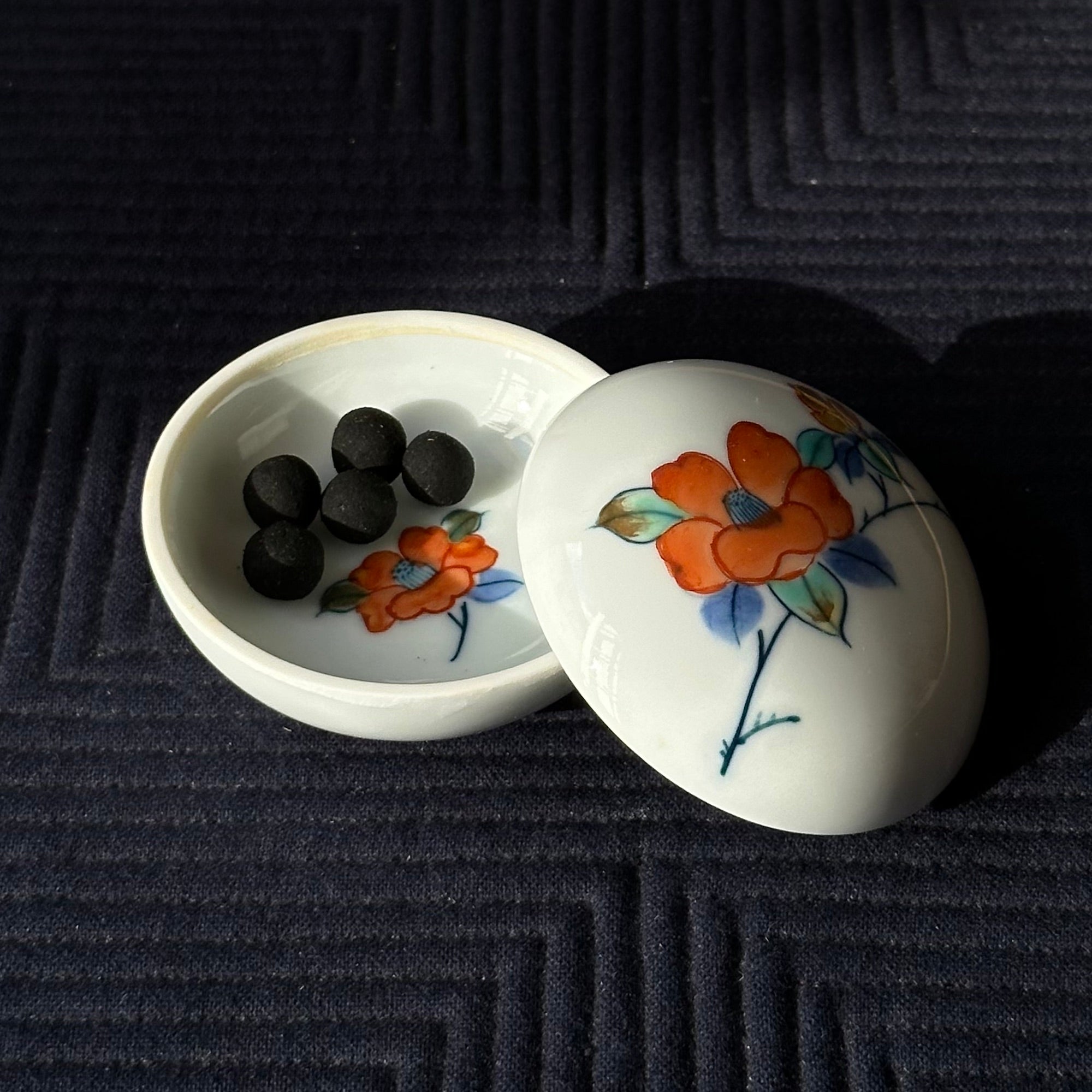 Kōgō en porcelaine Nabeshima, décor camélia de Shibata Gakuzan et nerikō (billes d’encens) japonais