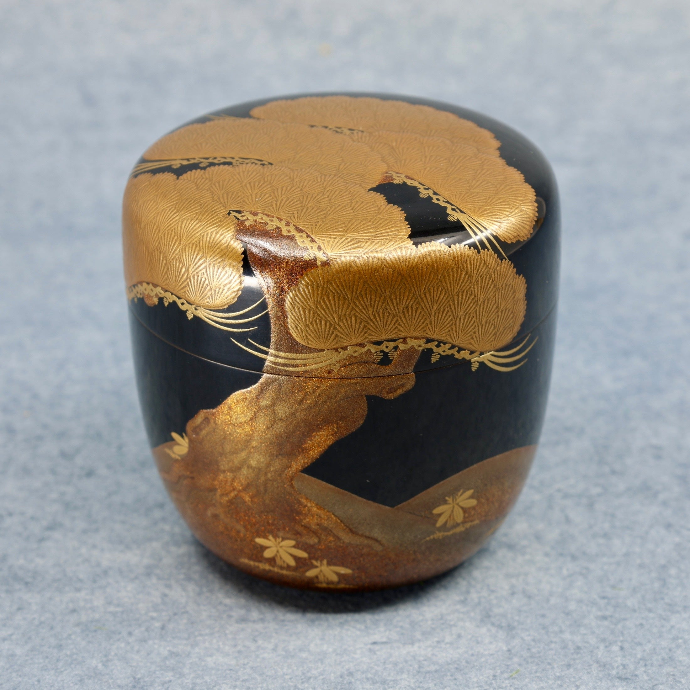 Natsume (Japanese tea caddy) in urushi lacquer and gold, decorated with oimatsu (old pine) and a Shiogama landscape by Suzuki Kōnyū