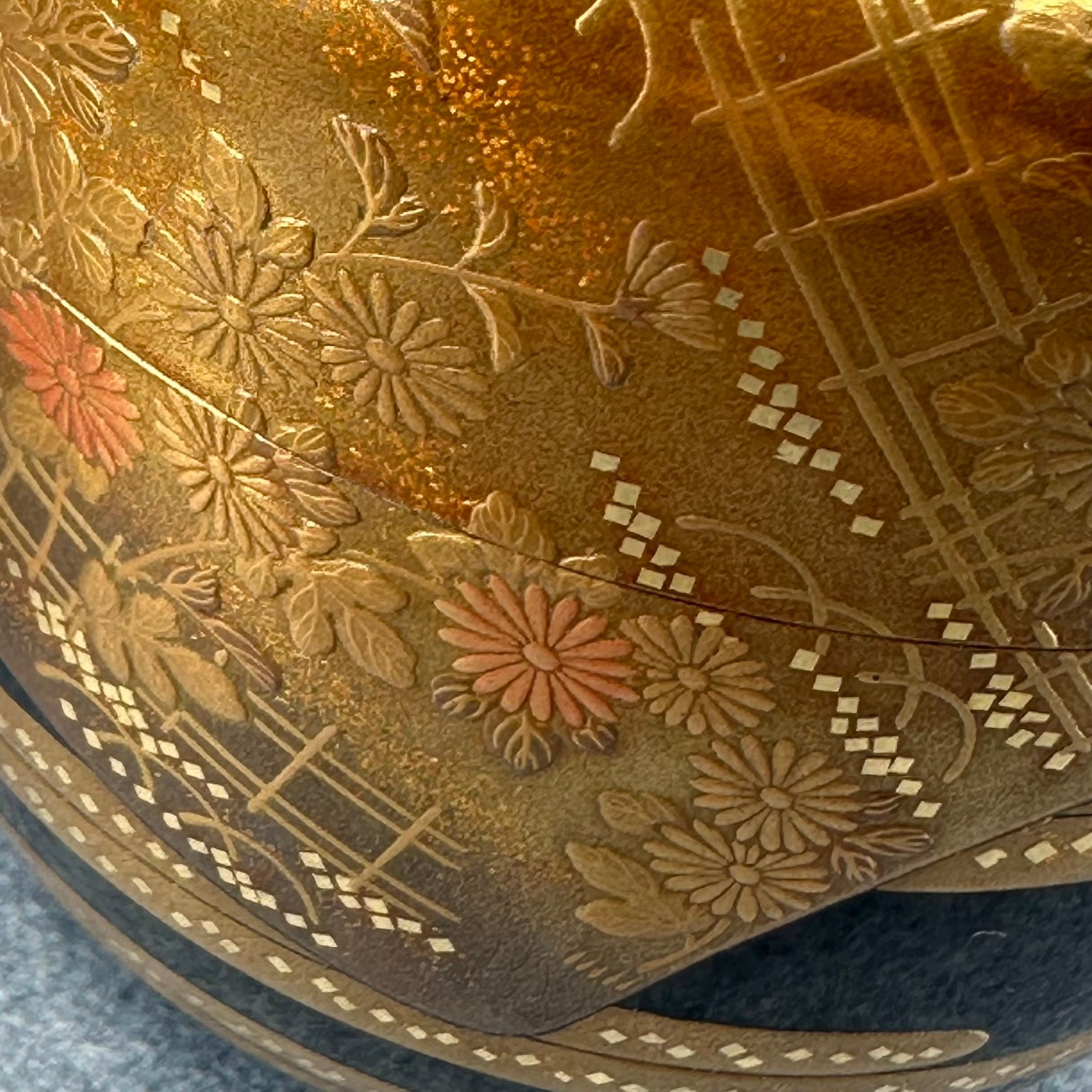 Détail en gros plan du décor en maki-e doré montrant la finesse du tracé des chrysanthèmes sur la laque noire roiro – Atelier Ikiwa
